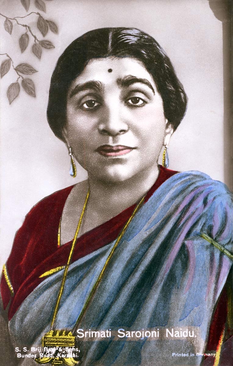 Hand-coloured printed portrait card of Sarojini Naidu in a crimson and blue-grey sari, captioned in the original print &lsquo;Srimati Sarojoni Naidu&rsquo;.